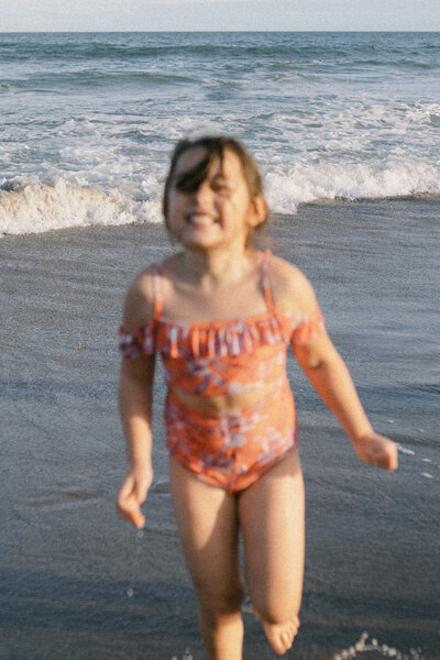 Child in swimsuit running towards camera