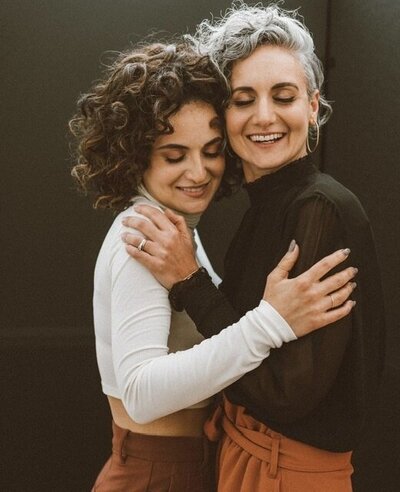 Elena and Concetta seen smiling and embracing in a field