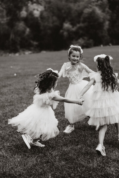 Flower girls twirl in tulle dresses during a joyful Breckenridge wedding celebration in the mountains.