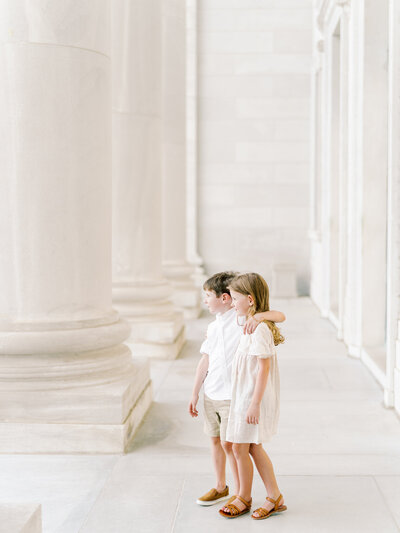 Brother and sister embrace while standing next to columns at the Arkansas State Capitol in Little Rock