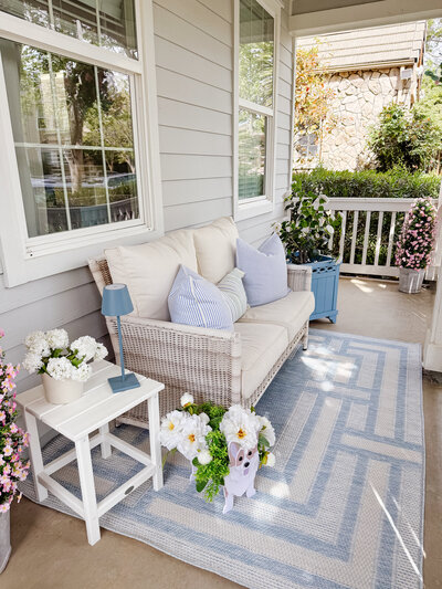 a front porch decorated with blues and neutrals
