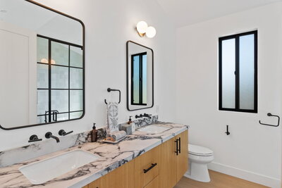 Double vanity bathroom with marble countertop, matte black fixtures, and modern mirrors in Los Angeles remodel
