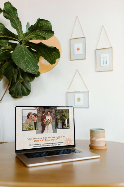 An open laptop on a table with a plant in the background, representing an example of web design and copywriting services.