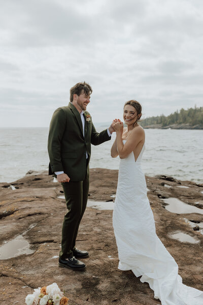 couple eloping on the north shore celebrating after saying their vows with lake superior in the background