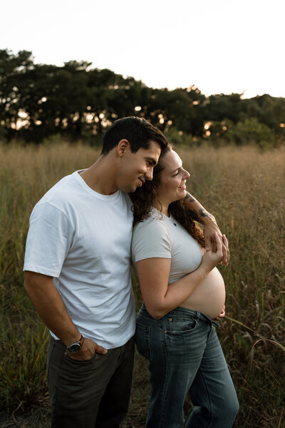 man hugging pregnant woman from behind