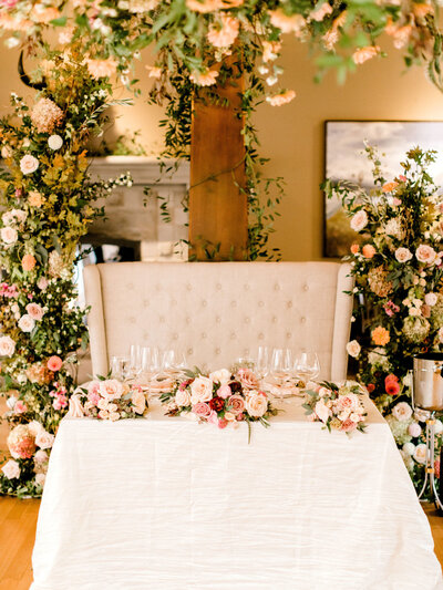 A sweetheart table and chandelier of blooms by Flowers By Janie, artful Calgary, Alberta wedding florist, featured on the Brontë Bride Blog.