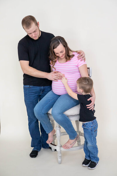 Photo of Family with hands on Mom's pregnant belly | Maternity Session