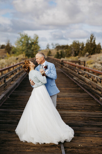 bride and groom holding hands while their bridal party is standing around them