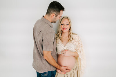 maternity photo in Springfield MO of mom smiling while husband looks down at her