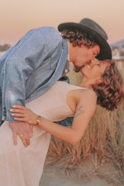 Oceanside, ca based engagement photographer capturing couple kissing in ocean beach, san francisco at golden hour
