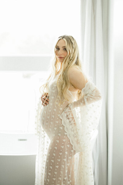 Expecting mother in white robe flowers maternity session by Sandra Vallejo Photography in Miami