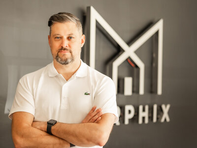 Balitmore headshots of business owner posing in his lobby in a white shirt