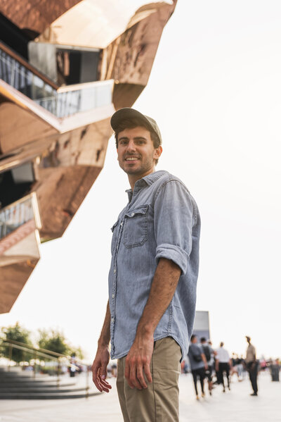 young-man-smiling-near-tall-building