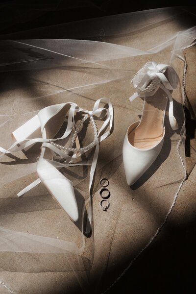 pair of bride's shoes and wedding rings displayed at charlotte ceremony