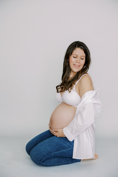 A beautiful pregnant mother gazes at her bump during her maternity photography session in Richmond, VA. 