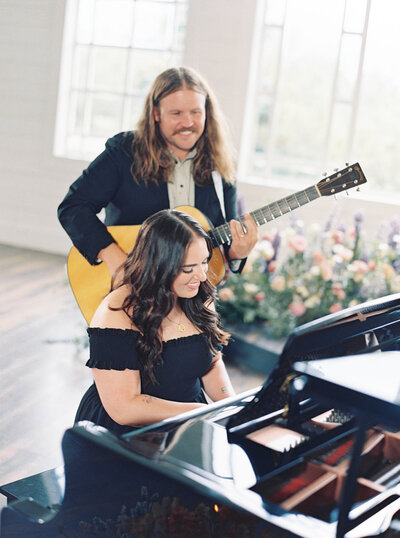 Mikaela Kahn live wedding vocalist playing piano while her husband Jordan plays guitar