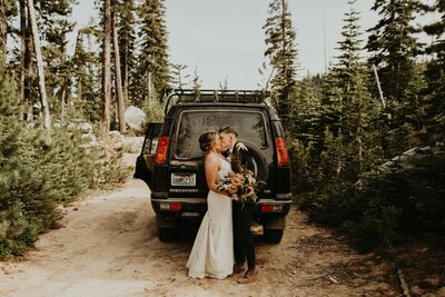 Two brides kidding in front of Land Rover on dirt mountain road near Leavenworth!