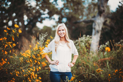 Woman standing among yellow wildflowers during a bright outdoor portrait session in Winter Garden, Florida