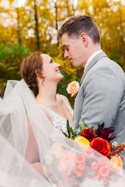 A bride holding a bouquet of flowers as she is about to kiss her groom