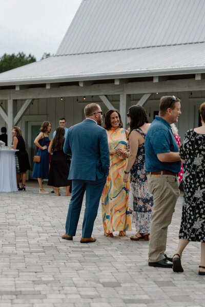 Group of wedding guests chat during cocktail hour