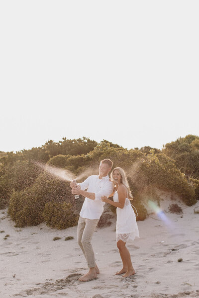 new jersey couple popping a bottle of champagne for their engagement photos