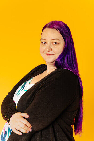 Heidi Thompson looking at the camera on a yellow background