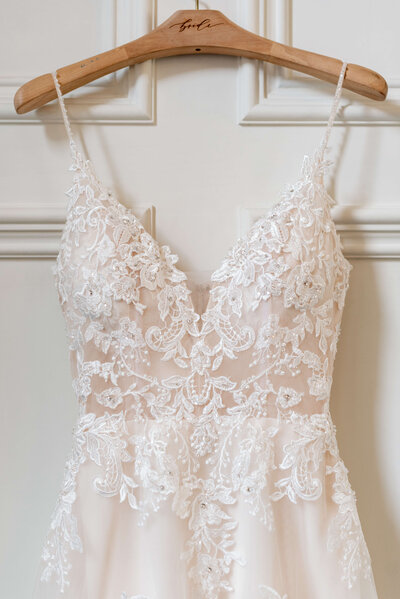 Bridal gown hanging on hanger by Karma Bridal