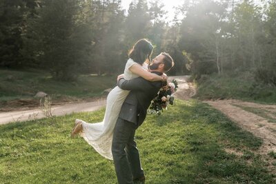 Big Sur wedding photographer captures man lifting bride during forest bridal portraits