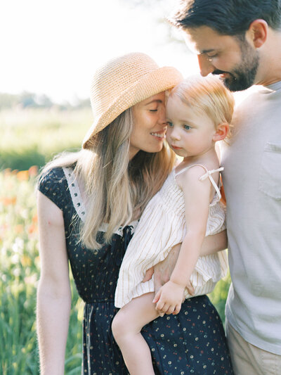 mom in a doen dress with girls in front of tuckahoe plantation flower garden by richmond family photographer