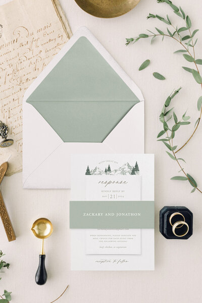 Custom forest green velvet wedding invitation pocket for an elevated Montana-style wedding featuring shades of sky blue and forest green, including a custom illustrated map. Perfect for unique wedding invitation ideas.