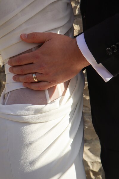 Close-up of a couple embracing during a wedding at Ashlar Ottawa, showing the bride’s dress and rings.
