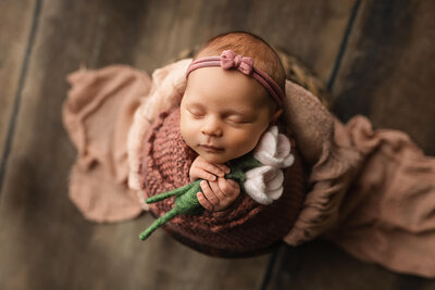 Beautiful baby boy wrapped in a hand knitted  green wrap with matching bonnet.