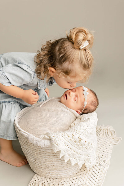 big sister giving baby kisses in portland studio pictures