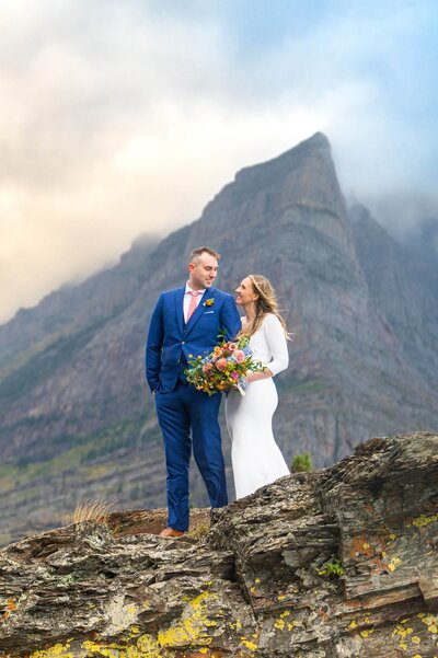 engaged couple at the top of utah mountains with wildflowers