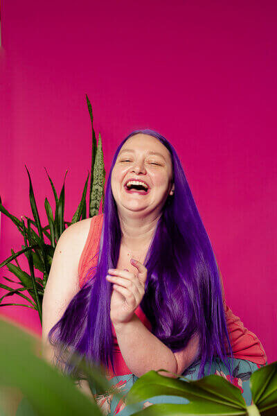 Wedding mareting expert Heidi Thompson sitting among plants laughing