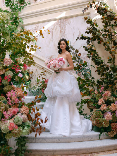 Bride stood in front of flowers at Gosford Hall