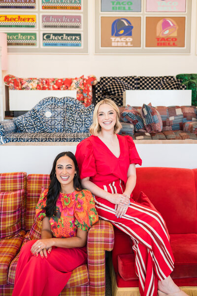 Dr. Brooks and Dr. Templeton, orthodontists in Nashville, TN sitting on a couch in bright colored outfits