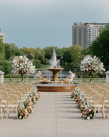 An outdoor wedding ceremony  in front of a fountain