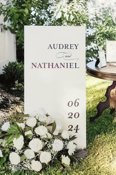 Custom A-frame wood welcome sign in black and white with a white floral arrangement at Ashford Acres Inn, Cynthiana, KY.