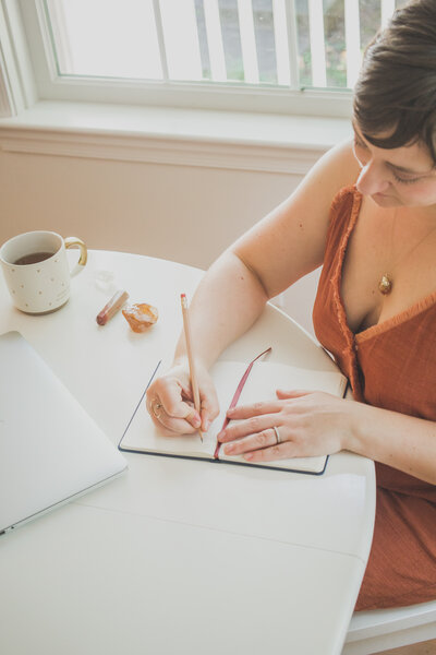 Ashley Stinson looking down, writing in a journal