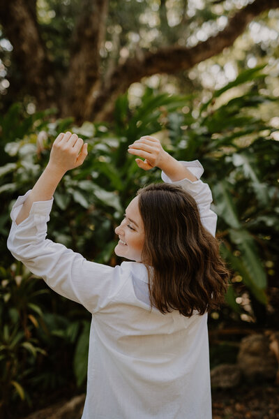 Intuitive healer twirls and smiles outdoors