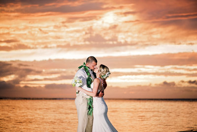 Stunning sunset bride and groom kiss on the beach on Maui