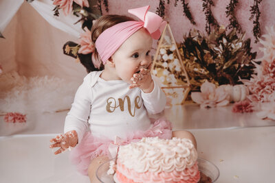 A baby having a cake smash at their first birthday party.