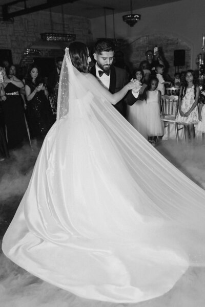 Bride and groom share their first dance at a wedding, surrounded by guests at grbic events, a luxury wedding venue in st. louis 