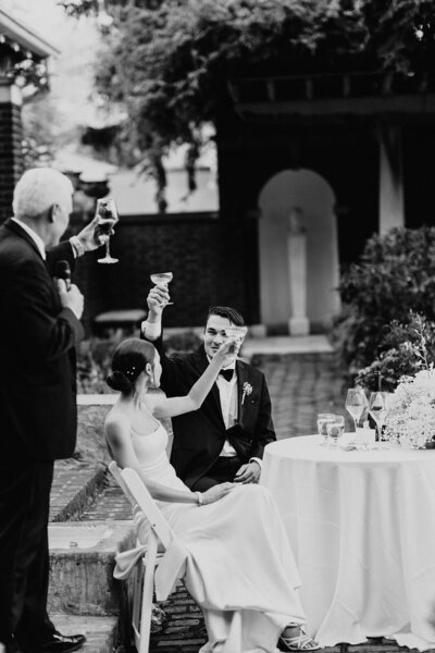 bride and groom raising their glasses after a toast al fresco at irwin gardens