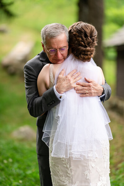 A bride and her father embrace after seeing her wedding dress for the first time at a Shenandoah National Park wedding, photographed by Nathan Sottung Photography, a Virginia wedding photographer.
