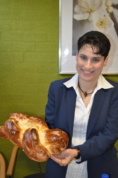 Rev-Chani-holds-large-challah-bread-and-smiles