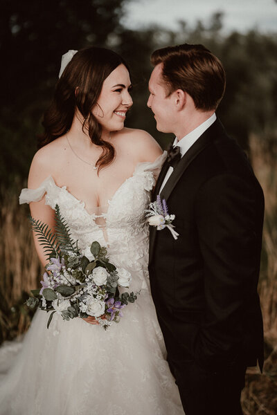 Wedding photographed in Auckland  at intimate and romantic ceremony. field, long grass, elegant, stylish, candid, loving, coromandel, photography, photograph, rustic, real, authentic, sand, backlit, backlight, sunset, evening