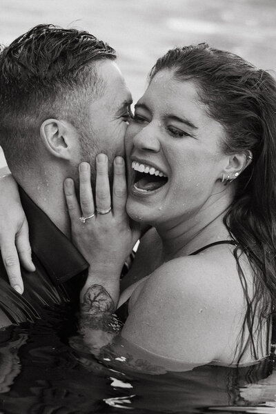 couple jumps in pool for engagement session