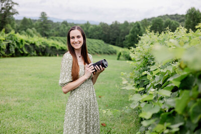 keri lindekugel atlanta photographer holding camera in vineyard